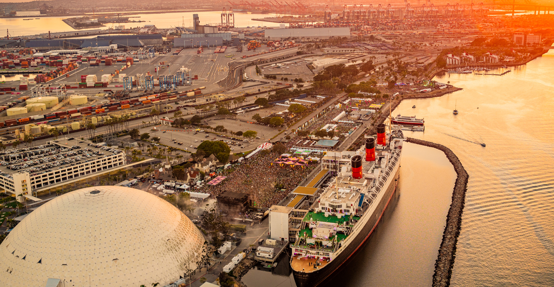 Sunlit Queen Mary ship gleaming against the Day Trip Festival skyline