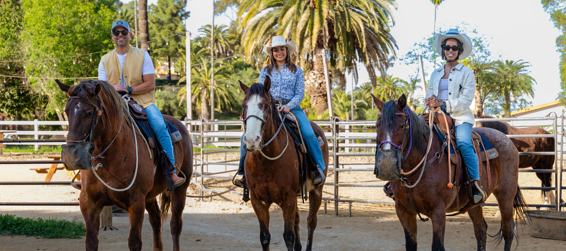 Riders on horseback at the ranch corral before their guided ride