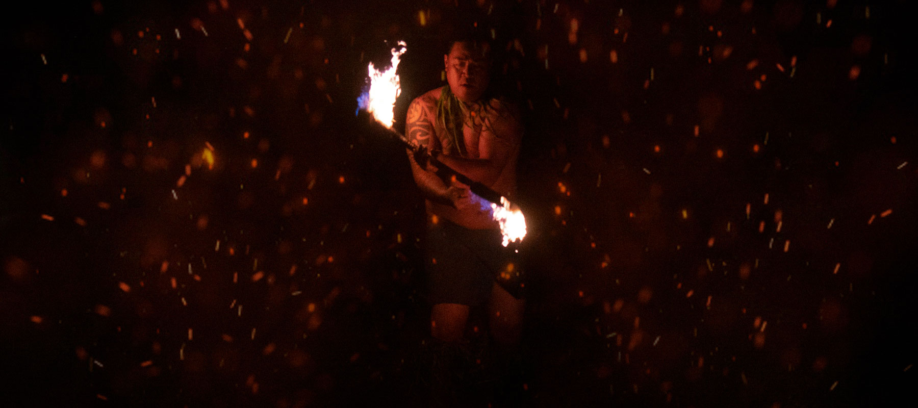 Polynesian fire performer in dynamic motion at the traditional luau on Maui