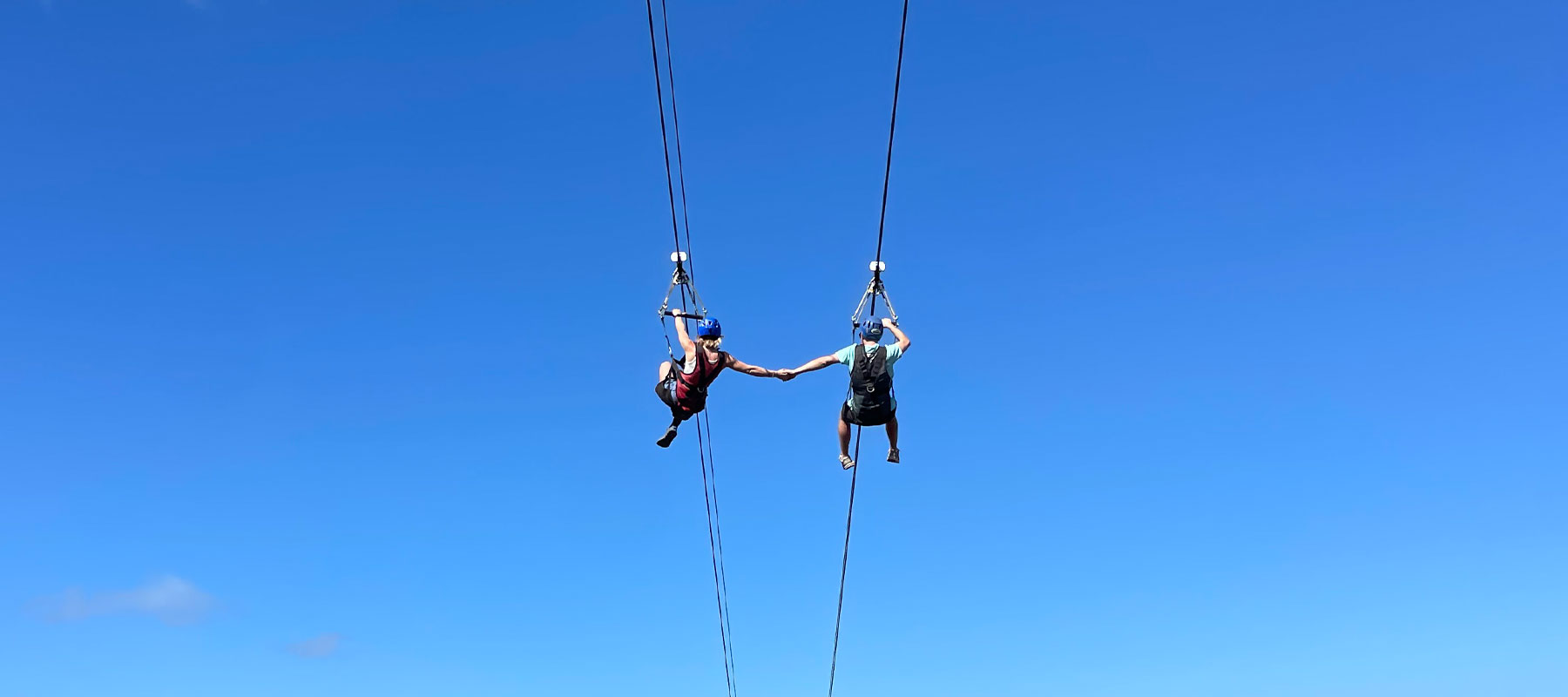 Guest ziplining over Kapalua valley with tropical mountain scenery in Maui