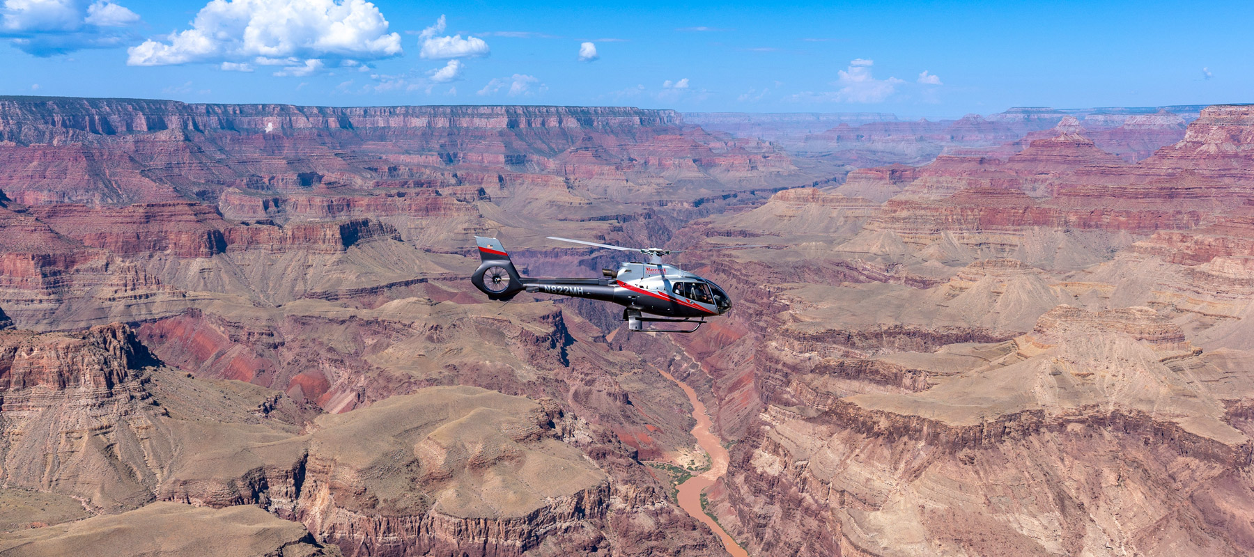 Helicopter crossing the expansive canyon landscape of Grand Canyon National Park