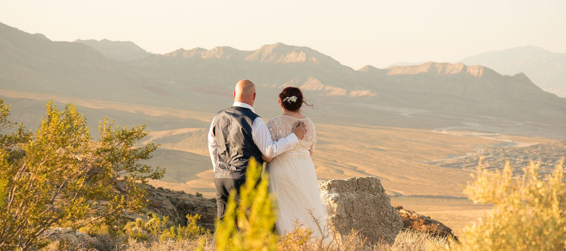 Newlyweds enjoying stunning desert mountain views after their helicopter wedding near Las Vegas
